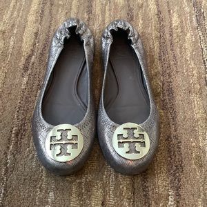 Tory Burch metallic flats with gold pendant.